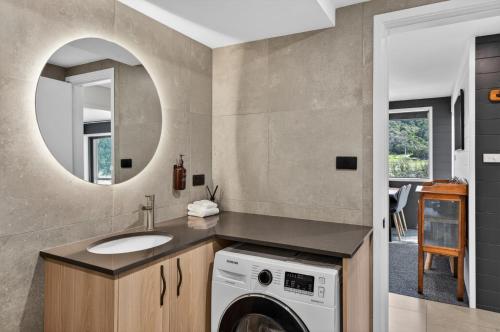 a bathroom with a washing machine and a sink at Tyrola 11 in Thredbo