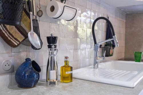a kitchen counter with a sink and a bottle of oil at Maisonnette climatisée in Aix-en-Provence