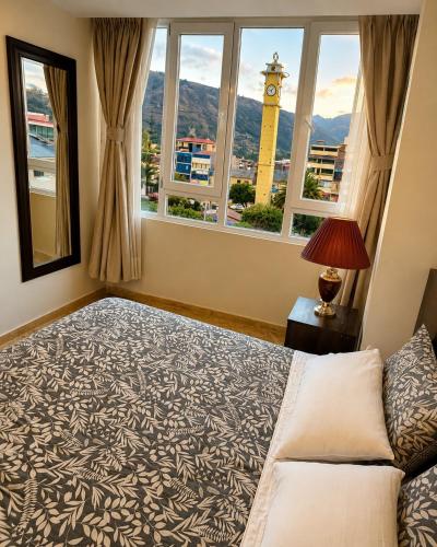 a bedroom with a large bed with a view of a clock tower at Chanka Suites in Talavera