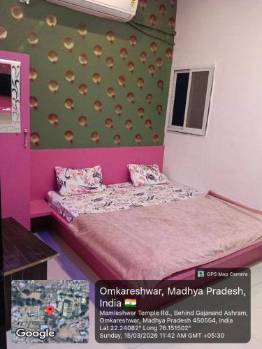 a small room with a bed and a wall with avertisement at Hotel Sadashiv in Godarpura