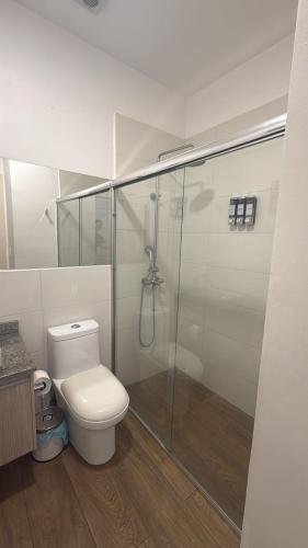 a bathroom with a toilet and a glass shower at Mumbai SkyLine Luxury Suite in Quito