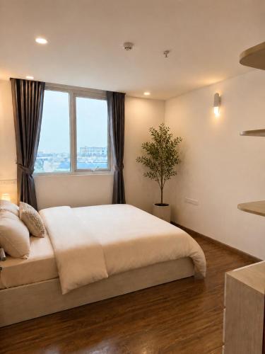 a bedroom with a large bed and a window at VEC Homes - Triển lãm VEC Đông Anh in Dong Anh