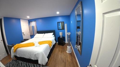 a blue bedroom with a bed and a mirror at Cozy Private Two Bedroom Basement Apartment in Hempstead