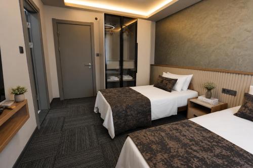 ein Hotelzimmer mit zwei Betten und einem Badezimmer in der Unterkunft Kaçkar Otel in Rize