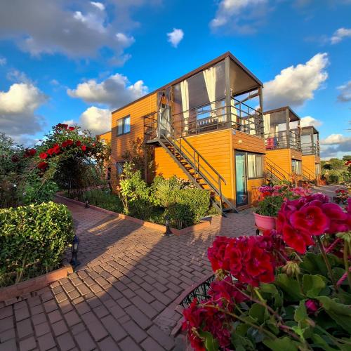 a yellow building with flowers in front of it at къщички Поляните in Sinemorets