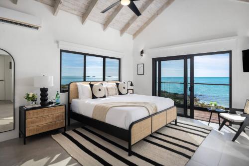 a bedroom with a bed and a view of the ocean at Opaline Villa 4BR 2Bath-Ocean Front in Providenciales