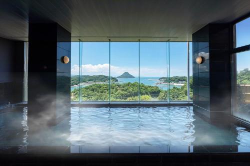 a room with a pool with a view of the ocean at Ooedo Onsen Monogatari Amakusa Hotel Kameya in Kami Amakusa