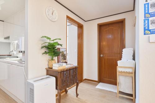 a kitchen with a door and a plant on a dresser at Stay GAON in Seoul
