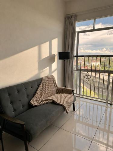 a living room with a couch and a large window at Taiping Centre Point Suite 7 by BWC in Taiping
