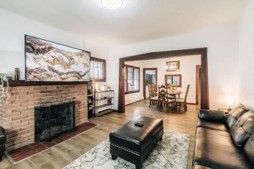 a living room with a brick fireplace and a tv at Minnehaha Falls Hideaway in Minneapolis