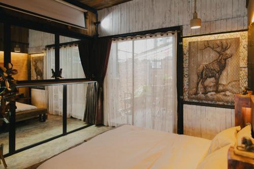 a bedroom with a bed and a window with a deer picture at New York Loft & Japanese Magic by V4SKIN in Bangkok