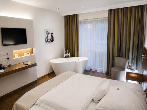 a hotel room with a bed and a bath tub at Wolfsburg Sandkamp Hotel by Belvilla in Wolfsburg
