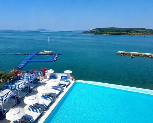 a swimming pool with chairs and a boat in the water at Latterace Resort in Yeosu