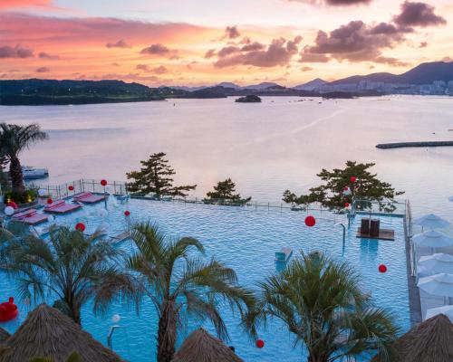 a resort swimming pool with a view of the water at Latterace Resort in Yeosu