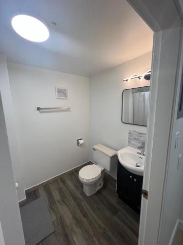 a white bathroom with a toilet and a sink at Stampeder Inn in Williams Lake