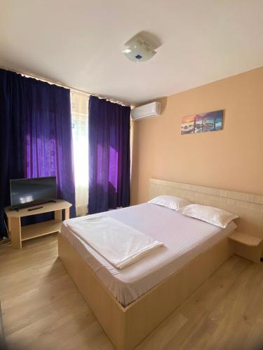 a bedroom with a large bed and a television at Casa Didina in Năvodari