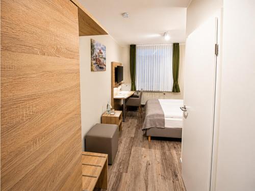 a hotel room with a bed and a desk at Wolfsburg Fallersleben Hotel by Belvilla in Wolfsburg