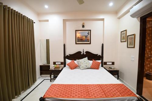 a bedroom with a large bed with red pillows at Hadendra Residences in Jaipur