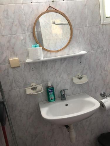 a bathroom with a sink and a mirror on the wall at Aidonofolies in Koukounaries