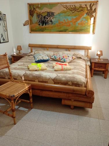 a bedroom with a wooden bed with pillows and a chair at B&B Zia Delia in Villaperuccio