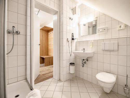 a bathroom with a toilet and a sink and a shower at Wolfsburg Fallersleben Hotel by Belvilla in Wolfsburg