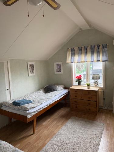 a bedroom with a bed and a dresser and a window at Lasmarmas in Älvkarleby