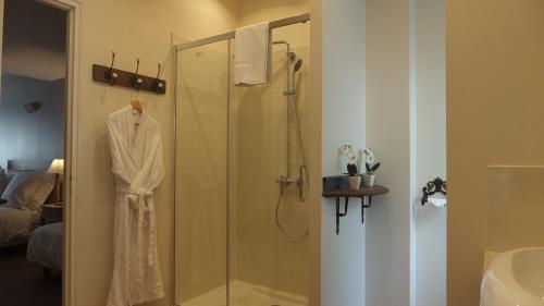 a bathroom with a shower with a robe on it at Hotel La Closeraie in Sully-sur-Loire