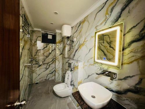 a bathroom with a toilet and a sink and a mirror at Sitara Premium Gangotri Palace, Tapovan in Rishīkesh