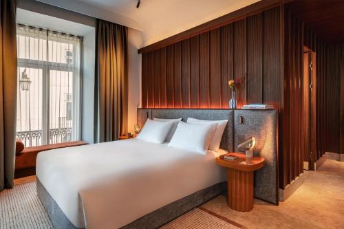a bedroom with a large white bed and a window at Andaz Lisbon, By Hyatt in Lisbon