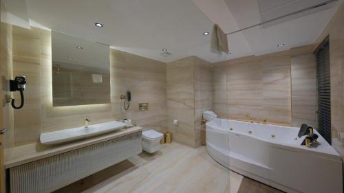 a bathroom with a tub and a toilet and a sink at Amorium Hotel in Kastamonu