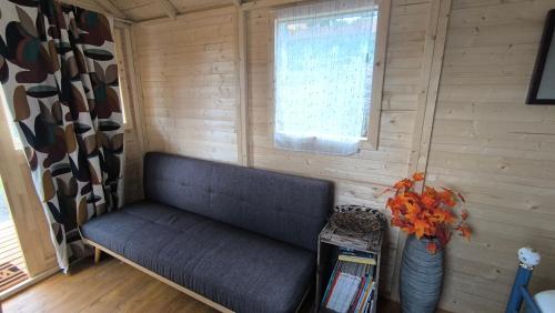 a blue couch in a room with a window at La Roulotte Cacahuète in Pont-d'Ouilly