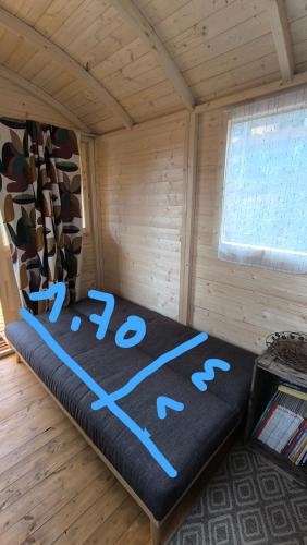 a room with a bed in a wooden room at La Roulotte Cacahuète in Pont-d'Ouilly