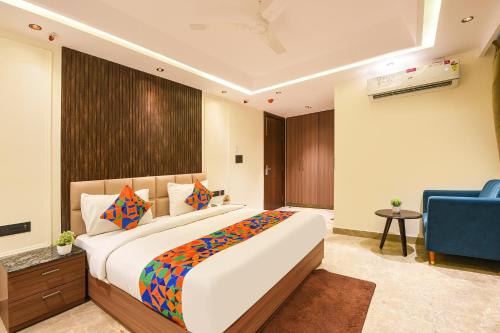 a bedroom with a large bed and a blue chair at Hotel Elvilla Model Town in New Delhi