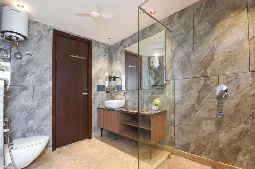 a bathroom with a sink and a glass shower at Hotel Elvilla Model Town in New Delhi
