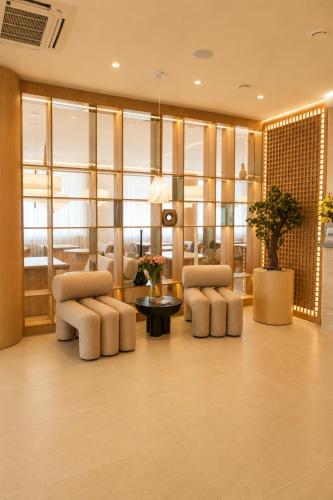 a lobby with two chairs and a table at Baitau Hotel Aktobe in Aktobe