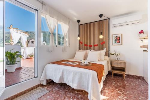 a bedroom with a bed and a large window at Studio with Terrace & Stunning Views in Güéjar-Sierra