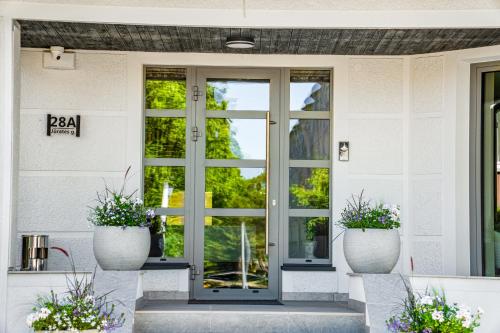 a front door of a house with two potted plants at Vila Ieva in Palanga