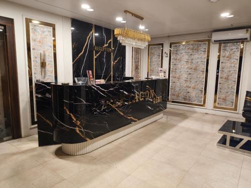 a lobby with a black marble counter with a chandelier at Pentagon Next Bhubaneswar in Bhubaneshwar