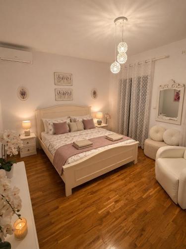 a white bedroom with a large bed and a couch at Villa Vida, Medulin - Bazen i jacuzzi in Medulin