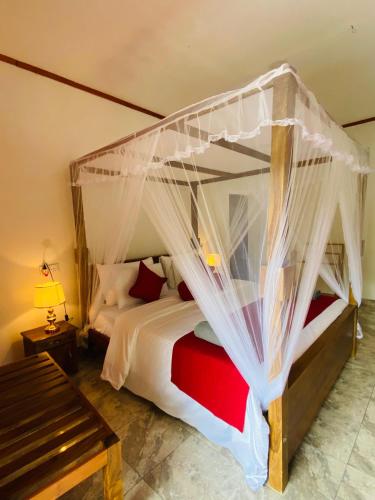 a bedroom with a large bed with a canopy at Rawana Mountain View Homestay in Ella