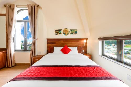 a bedroom with a bed and two windows at Maro Boutique Villa in Da Lat