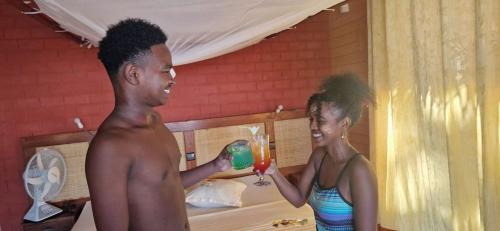 a man and a woman holding a drink in a room at Antsanitia - Domaine du Mandravasarotra - DDM in Antsianitia