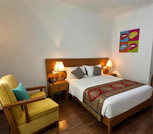 a bedroom with a bed and a chair and two lamps at Fude Hotel T bilis第比利斯富德酒店 in Tbilisi City