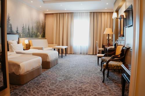 a hotel room with a bed and a couch and chair at Grand Hotel Victory in Aktau