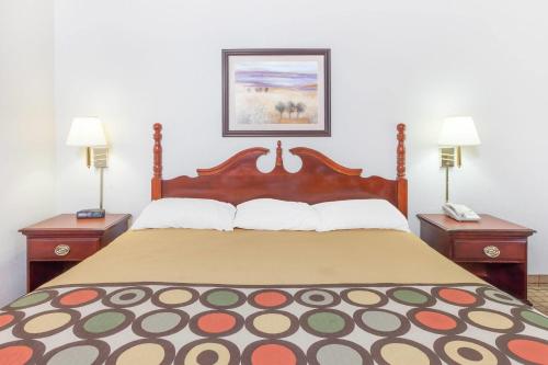 a bedroom with a large bed with two night stands at Super 8 by Wyndham Conway in Conway