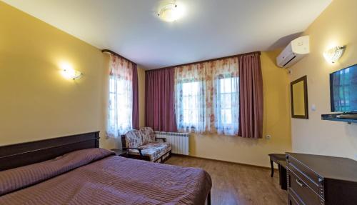a hotel room with a bed and a chair at Complex Rayuvski Han in Rayuvtsi