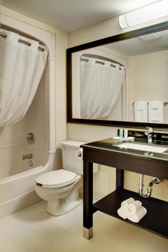 a bathroom with a toilet and a sink and a mirror at Clarion Pointe in Campbellton