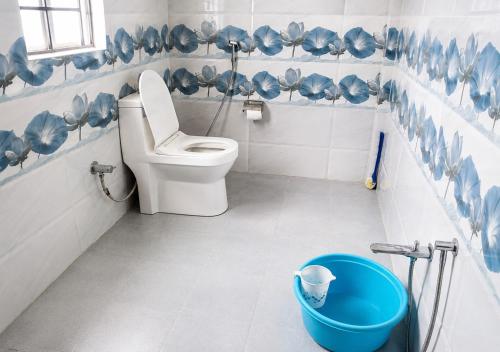 a blue and white bathroom with a toilet and a bucket at Perfect View Homestay in Cherrapunji
