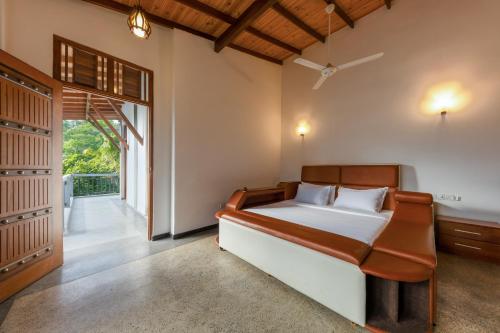 a bedroom with a bed and a large window at Nova By Horizon Collection in Unawatuna