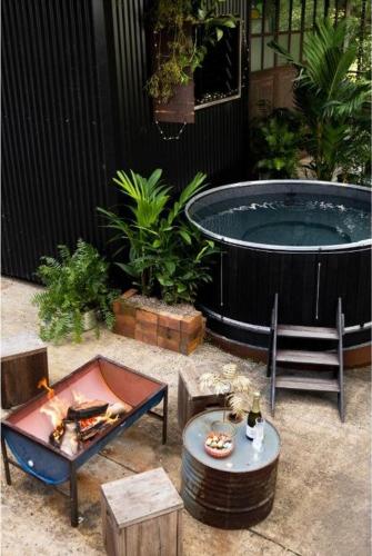 a patio with a hot tub and a table and a table sidx sidx at The Bangalow Barn in Bangalow
